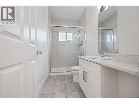 A white bathroom with a glass shower door and a toilet.