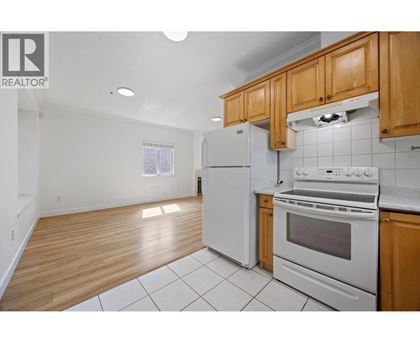 A kitchen with white appliances and wooden cabinets.