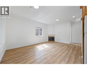 A spacious room with wooden flooring and white walls.