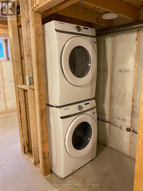Two white front load washing machines in a construction site.