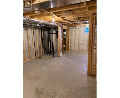 A room under construction with exposed pipes and wooden framing.