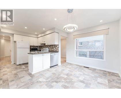 A well-lit kitchen with a tiled floor and a large window.