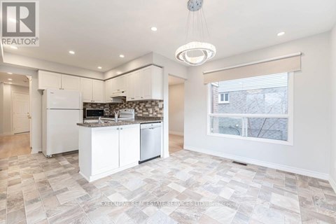 A well-lit kitchen with a tiled floor and a large window.