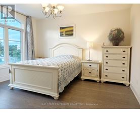 A bedroom with a large bed, a nightstand, and a dresser.