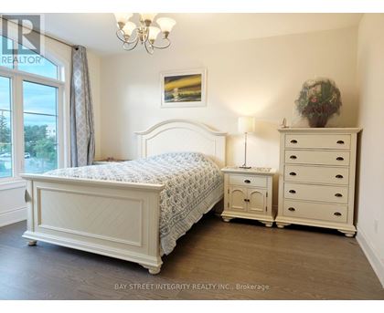 A bedroom with a large bed, a nightstand, and a dresser.