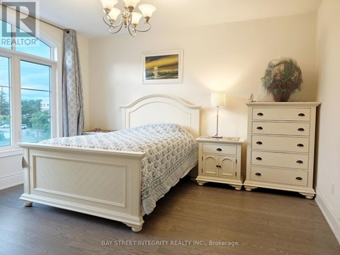 A bedroom with a large bed, a nightstand, and a dresser.