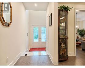 A hallway with a glass display case and a mirror on the wall.