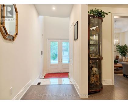 A hallway with a glass display case and a mirror on the wall.