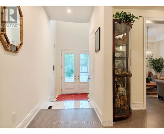 A hallway with a glass display case and a mirror on the wall.