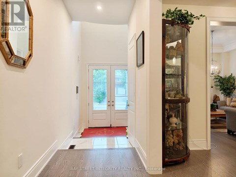 A hallway with a glass display case and a mirror on the wall.