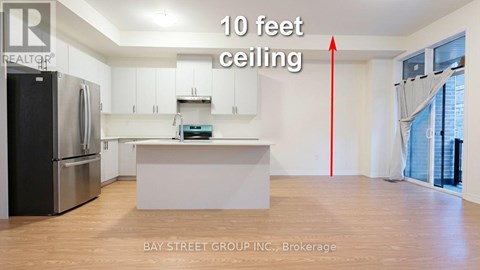 A kitchen with 10 feet ceiling and a refrigerator.