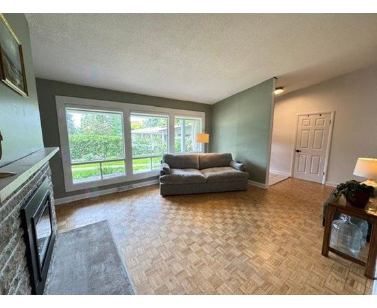 A living room with a couch, a table, and a fireplace.