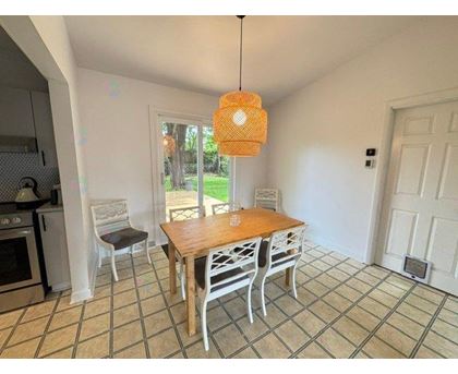 A kitchen with a table and chairs.
