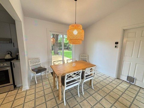 A kitchen with a table and chairs.