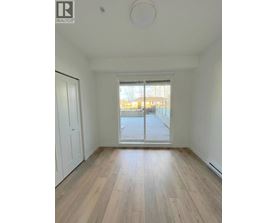 A room with wooden flooring and a sliding glass door leading to a balcony.