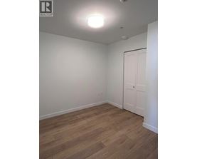 A room with a white door and wooden flooring.