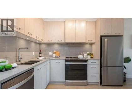 A modern kitchen with white cabinets and stainless steel appliances.