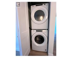 Two front loading washing machines in a small laundry room.