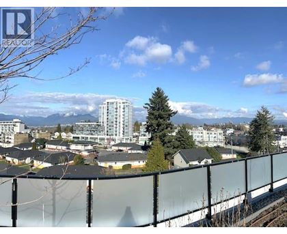 A view of a residential area with apartment buildings and houses with a clear blue sky in the background.