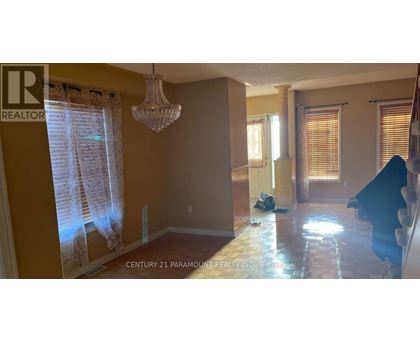 A room with a chandelier and a window with curtains.