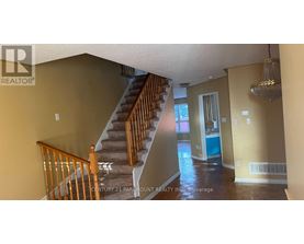 A staircase with wooden railings leads to a bedroom with a blue door.
