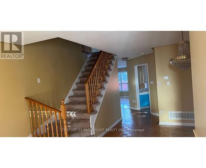 A staircase with wooden railings leads to a bedroom with a blue door.