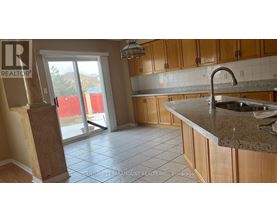 A kitchen with wooden cabinets and a granite countertop.