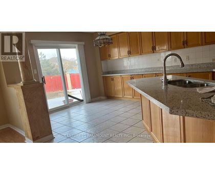 A kitchen with wooden cabinets and a granite countertop.