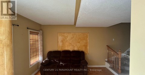 A living room with a couch and a window with blinds.