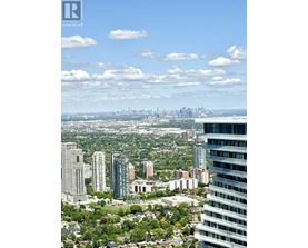 A cityscape with a mix of residential and commercial buildings under a clear sky.
