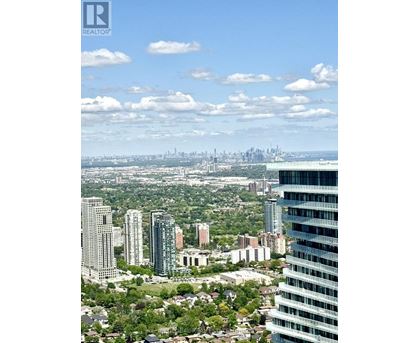 A cityscape with a mix of residential and commercial buildings under a clear sky.