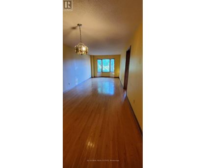 A room with wooden floors and a chandelier hanging from the ceiling.