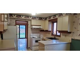 A kitchen with a refrigerator, stove, and sink.