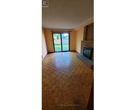 A room with a wooden floor and a fireplace.