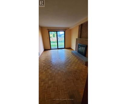 A room with a wooden floor and a fireplace.