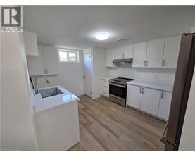 A kitchen with white cabinets and a wooden floor.