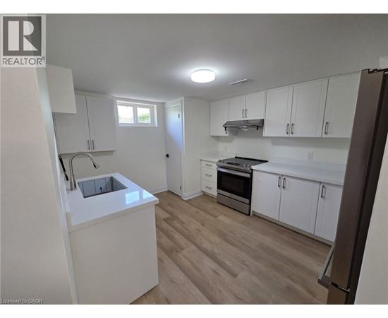 A kitchen with white cabinets and a wooden floor.