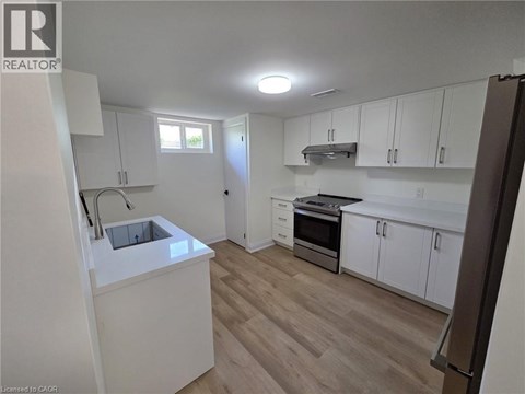 A kitchen with white cabinets and a wooden floor.