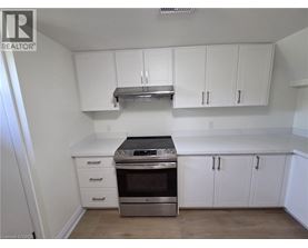 A kitchen with white cabinets and a stainless steel range hood.