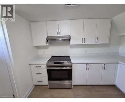 A kitchen with white cabinets and a stainless steel range hood.