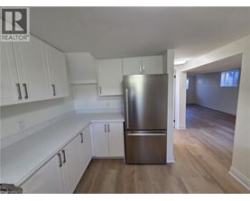 A kitchen with white cabinets and a stainless steel refrigerator.