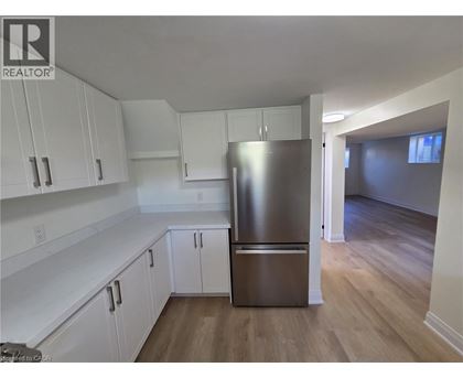 A kitchen with white cabinets and a stainless steel refrigerator.