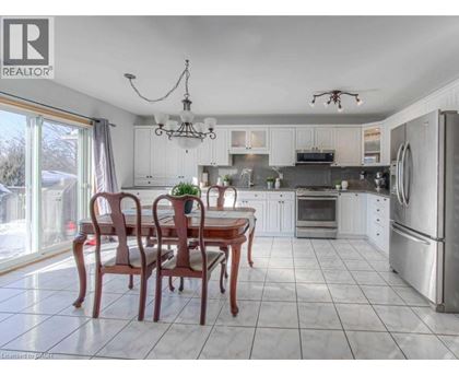 A well-lit kitchen with a dining table and chairs.
