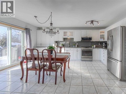A well-lit kitchen with a dining table and chairs.