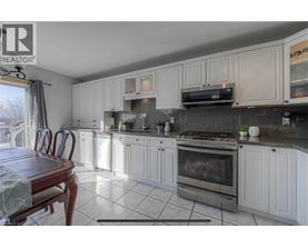 A kitchen with white cabinets and a wooden table.