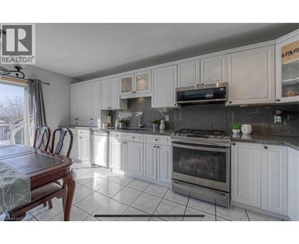 A kitchen with white cabinets and a wooden table.