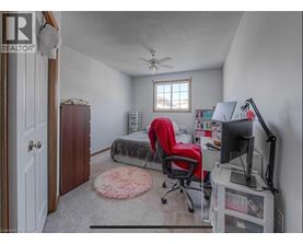A bedroom with a bed, desk, and chair.