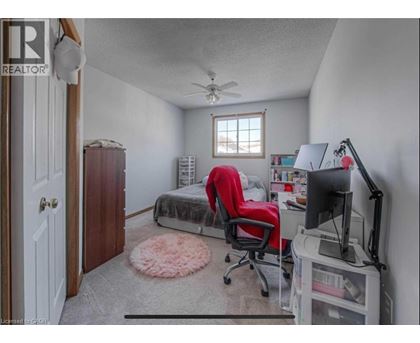 A bedroom with a bed, desk, and chair.