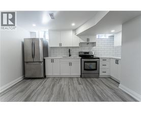 A kitchen with a refrigerator, oven, and cabinets.