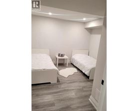 A bedroom with two beds and a nightstand.